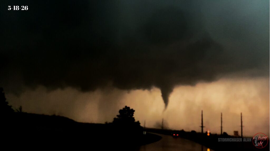 Halfway condensed tornado with clear debris field on the ground.